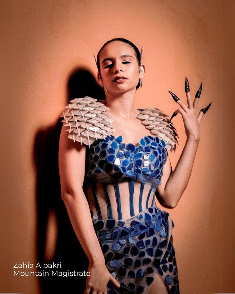 Zahia Albarki — blue 3D printed scale-like shoulder piece over a printed corset